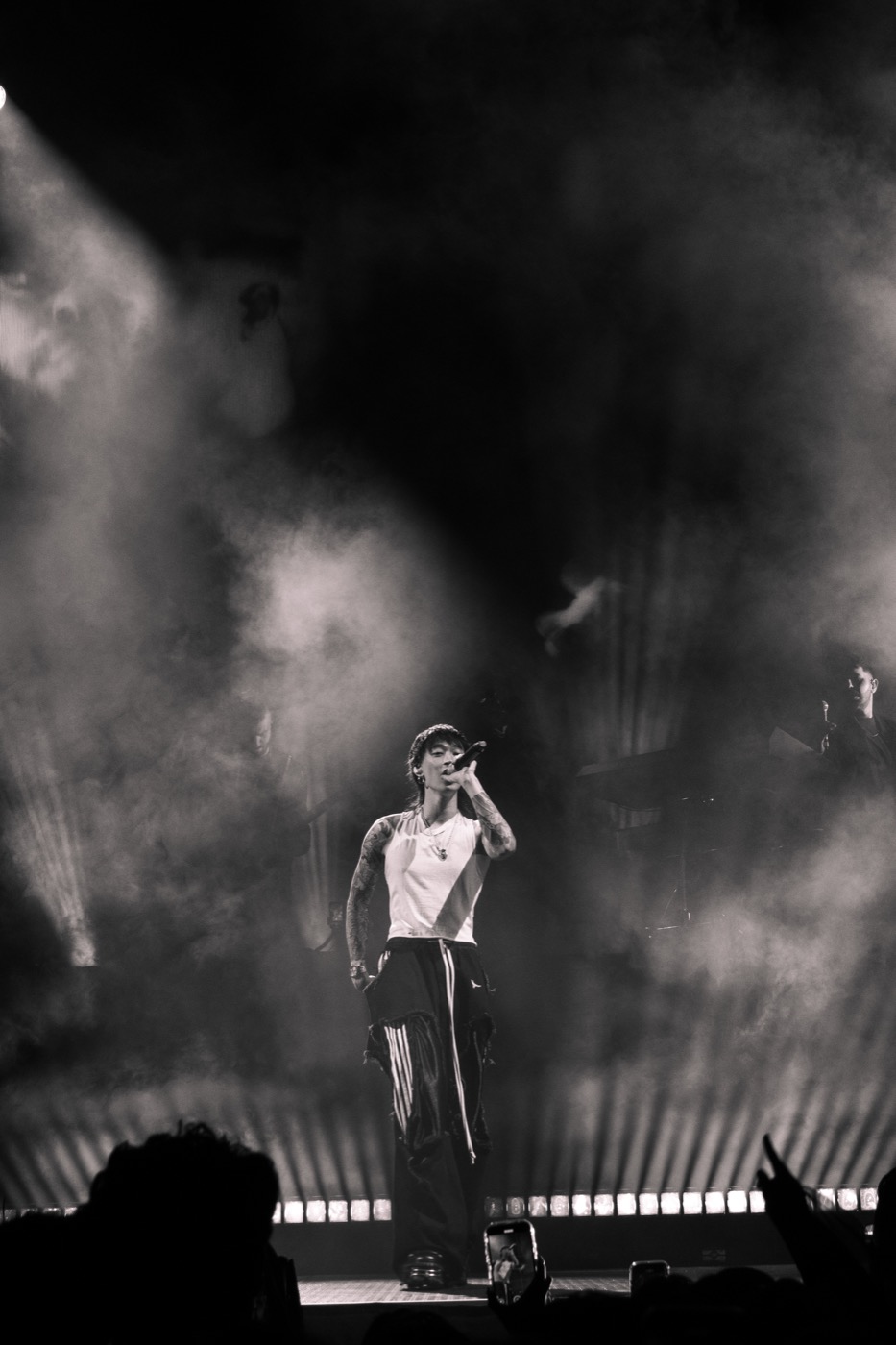 Black-and-white wide photograph of Keshi performing amid stage fog