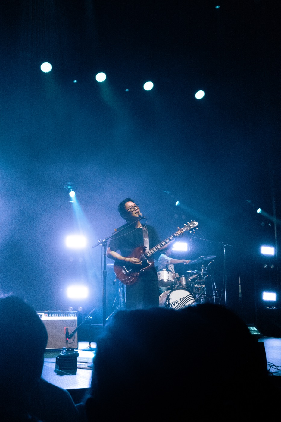 Wide blue-lit photograph of Wave to Earth performing in San Francisco
